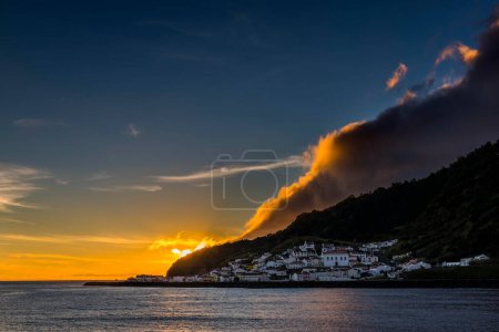 Pequeño pueblo junto al mar, puesta de sol con espectaculares nubes detrás de las cordilleras, Ribeira Quente, Sao Miguel, Azores, Portugal, Europa