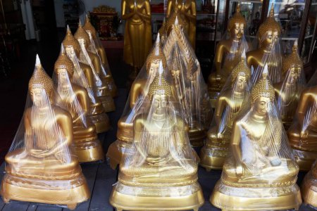 Buddha statues in foil, for sale, devotional business in the Buddha Road, Thanon Bamrung Meuang, Phra Nakhon, Bangkok, Thailand, Asia