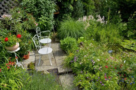 Asiento en el jardín con sillas blancas