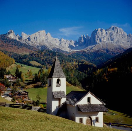 Automne à la petite église de Saint-Cyprien dans la vallée de Tiers, au-dessus du Catinaccio avec les tours Vajolett. I-Italie, Dolomites
