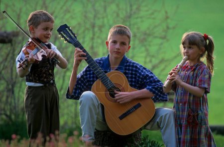 children play music in the group, flute, guitar and violin