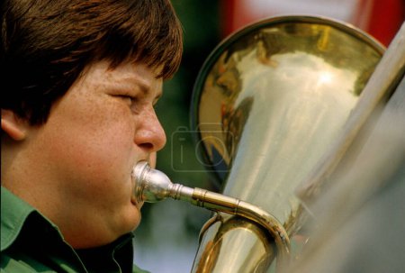 Close up view of Boy blows trumpet