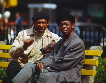 African men sitting on a bench talking to each other