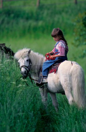 Girl riding on pony