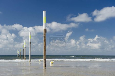 Playa y postes marcadores contra el cielo, San Pedro-Ording