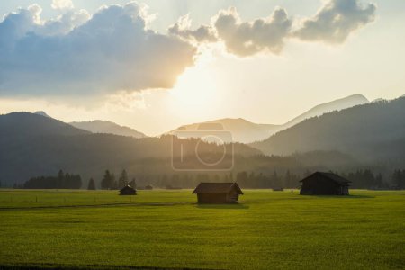 Wiesen mit Heuscheune und Sonnenuntergang in Mittenwald, dahinter Estergebirge, Werdenfelser Land, Oberbayern, Bayern, Deutschland, Europa