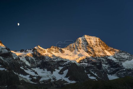 Snow-capped Breithorn with moon at sunset, Lauterbrunnen Valley, Swiss Alps, Jungfrau-Aletsch, Bernese Oberland, Bernese Highlands, Bern, Switzerland, Europe