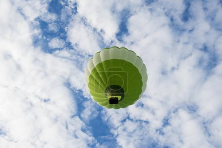 Green Green hot air balloon in front of blue sky with clouds, France, Europe