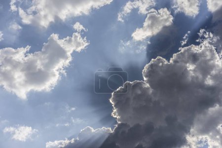 Dark clouds, rain clouds with concealed Sun and sunbeams