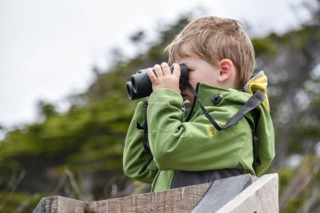 Niño interesado mirando a través de prismáticos, Punta Arenas, Patagonia, Chile, América del Sur