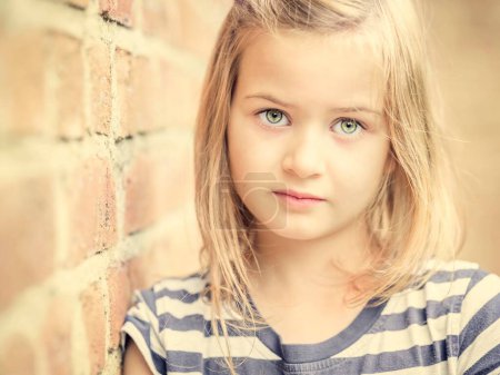 Girl, 10 years, leans against a wall, direct view, face, portrait, Germany, Europe