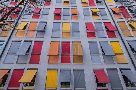Facade of a residential building with colourful roller blinds, Munich, Upper Bavaria, Bavaria, Germany, Europe