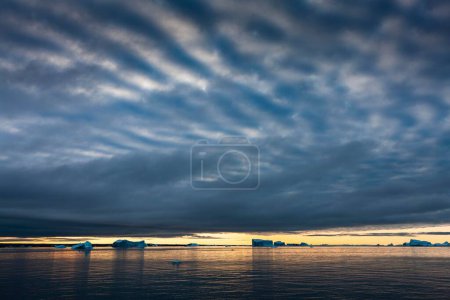 Icebergs at sunrise in the Arctic Sea, Scoresbysund, East Greenland