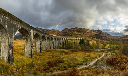 Glenfinnan railway viaduct, with autumn colours and cloudy sky, Glenfinnan, West Highlands, Scotland, Great Britain