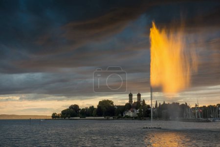 Springbrunnen und Gewitterwolken bei Sonnenuntergang, Schlosskirche im Hintergrund, Friedrichshafen, Bodensee, Baden-Württemberg, Deutschland, Europa 