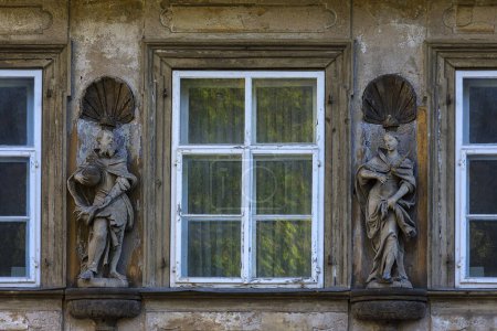 Wooden sculptures of Emperor Heinrich II and Empress Kunigunde on a facade of a house between windows, Bamberg, Upper Franconia, Bavaria, Germany, Europe