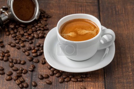 Foto de Fresh double espresso coffee and coffee beans on wooden table - Imagen libre de derechos