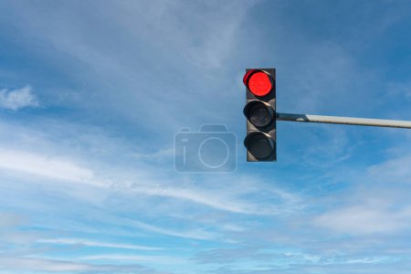 Téléchargez les photos : Modern traffic light with red light in front of cloudless sunny blue sky - en image libre de droit