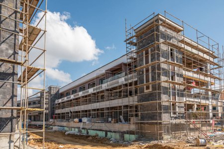 Photo for Construction scaffolding built on a new apartment building. new construction under construction - Royalty Free Image