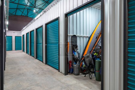 Photo for Outdoors activity items seen through the open door of the self storage unit. Rental Storage Units - Royalty Free Image