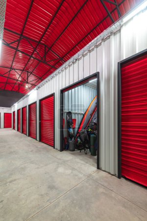 Corredor de unidad de self storage con puertas rojas. Unidades de almacenamiento de alquiler