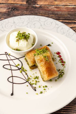 Téléchargez les photos : Baklava traditionnelle aux pistaches à dessert turques sur une assiette en porcelaine blanche - en image libre de droit