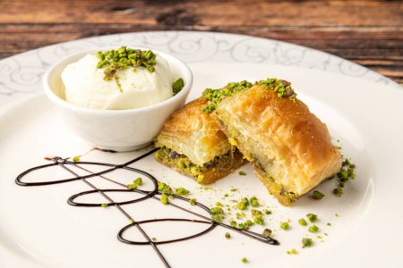 Téléchargez les photos : Baklava traditionnelle aux pistaches à dessert turques sur une assiette en porcelaine blanche - en image libre de droit