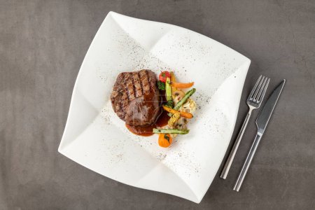 Téléchargez les photos : Filet de bœuf grillé avec sauce Demi glace aux légumes grillés sur une assiette en porcelaine blanche - en image libre de droit