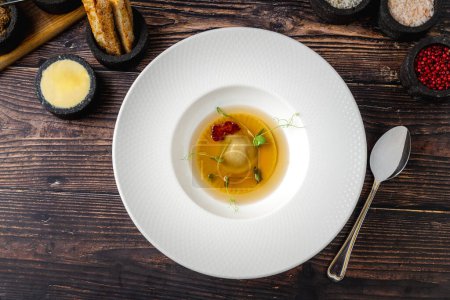 Téléchargez les photos : Ravioli consomme sur une assiette en porcelaine blanche. Concept de saine alimentation - en image libre de droit
