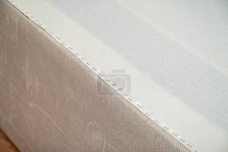 Téléchargez les photos : Nouveau tissu appliqué avec agrafes pour remplacer l'interligne fusible usé sous le canapé - en image libre de droit