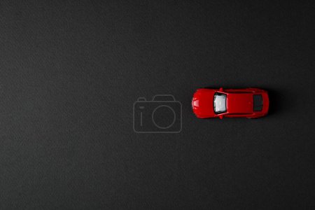 vista superior de juguete coche rojo sobre fondo oscuro