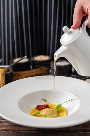 Téléchargez les photos : Ravioli consomme sur une assiette en porcelaine blanche. Concept de saine alimentation - en image libre de droit