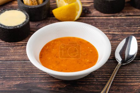 Ezogelin soup in white porcelain plate, on wooden table