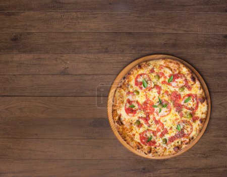 Foto de Pizza Marguerita hecha con sabrosa masa de pizza, Mozzarella, tomates, mejorana y aceitunas verdes. Servido en una tabla de madera. Pizza Napolitana. Gastronomía refinada. Fotografía gourmet de la parte inferior derecha. - Imagen libre de derechos