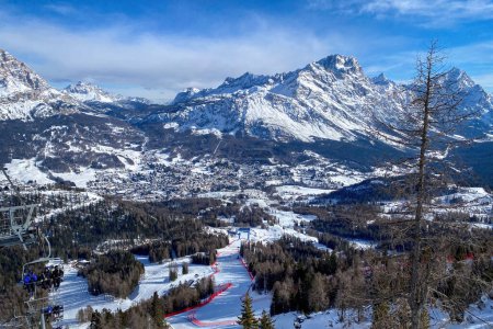 Szenische Ansicht der Tofana-Skirennpiste in Cortina d 'Ampezzo in Italien vor schneebedecktem Berg Punta Sorapiss und blauem Himmel