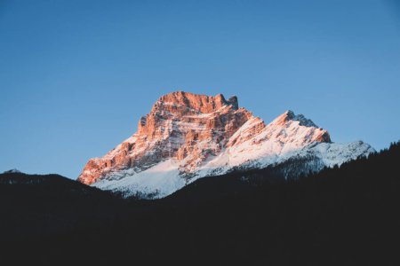 Vista panorámica de la montaña Spella Est y Pelmo de color naranja en los Dolomitas, Italia al amanecer contra el cielo azul en invierno