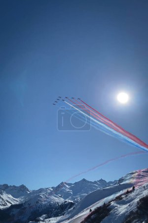 Photo for Patrouille de France, the official aerobatic team of the French Air Force, over Meribel and the French alps against blue sky - Royalty Free Image