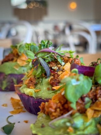 Veganes Frühstück auf pflanzlicher Basis aus lila Süßkartoffeln mit Avocado und Toppings