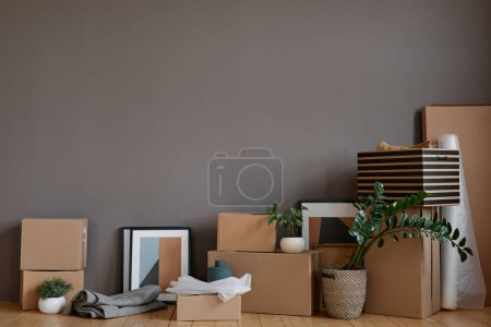 Téléchargez les photos : Horizontal pas de photos de boîtes déballées et divers trucs placés dans la chambre loft contre le mur gris - en image libre de droit