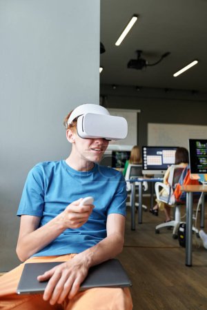 Photo for Vertical image of student using VR glasses at lesson in the classroom - Royalty Free Image