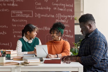 Téléchargez les photos : Groupe de jeunes Afro-Américains discutant d'un projet scolaire en classe - en image libre de droit