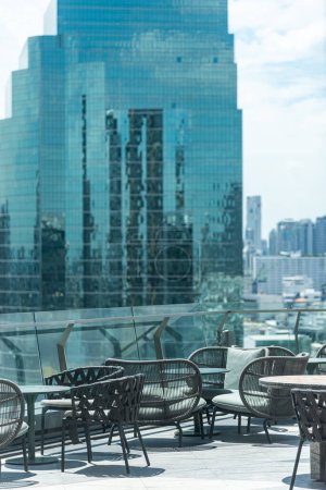 Photo for Roof top sky bar table seat with blur skyscraper view background - Royalty Free Image