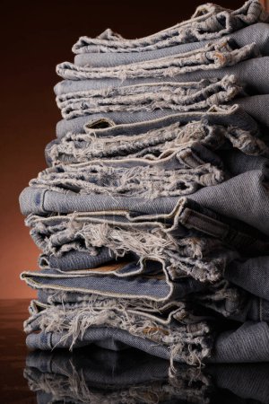 Photo for Neatly folded, but tattered laundry - blue jeans - Royalty Free Image