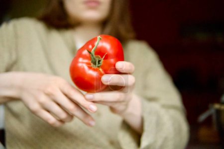 Téléchargez les photos : Jeune femme tenant de grosses tomates rouges mûres dans sa main - en image libre de droit