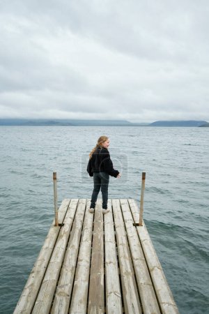 Photo for Girl on wooden pier near sea - Royalty Free Image