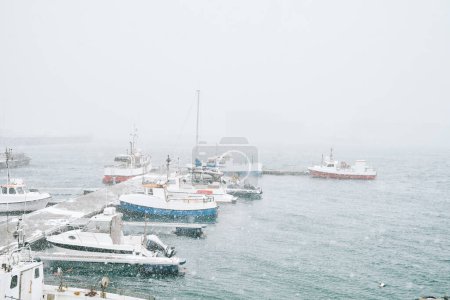 Foto de Yates amarrados en el agua de mar ondulante cerca del puerto contra el cielo gris durante el tiempo tormentoso - Imagen libre de derechos