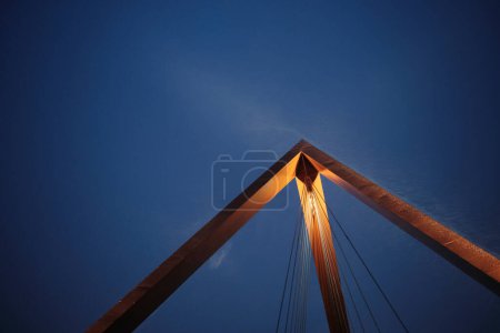 Photo for From below pyramid shaped structure of Teiknistofan Trod bridge with cords located against cloudless blue sky in evening in Reykjavik, Iceland - Royalty Free Image
