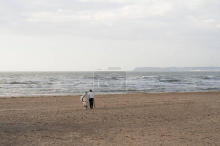 Foto de Vieja y joven aislada camina por la playa de Trouville sur Mer - Imagen libre de derechos