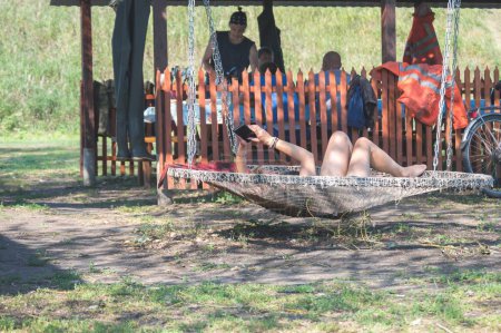 Téléchargez les photos : Travailleurs déjeunant en plein air, femme allongée dans un hamac - en image libre de droit