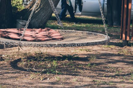 Foto de Hamaca redonda con manta para relajarse en el árbol cerca del coche - Imagen libre de derechos